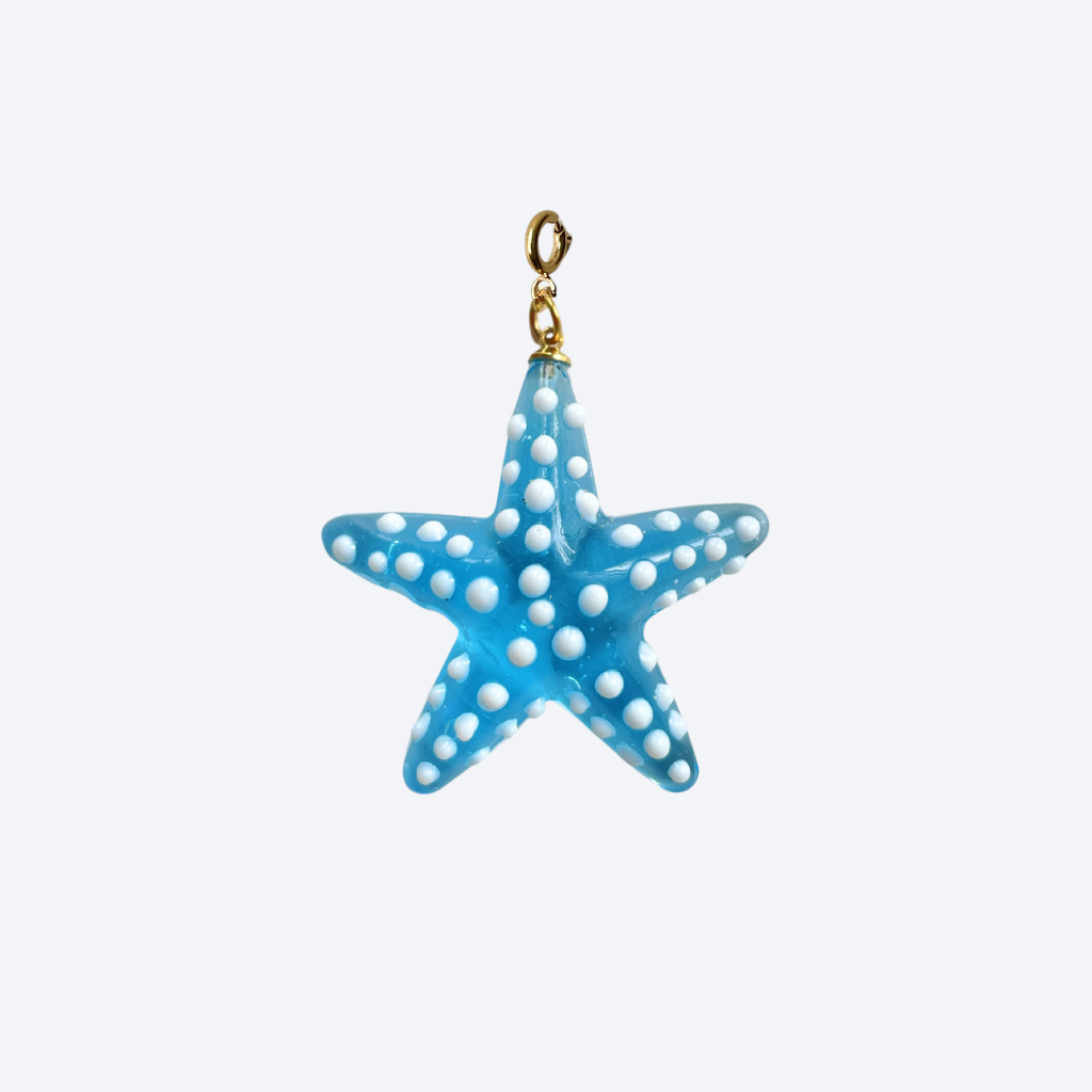 Close-up of the Ocean Star Pendant, a turquoise glass starfish charm with white dot details and 18K gold-plated finish