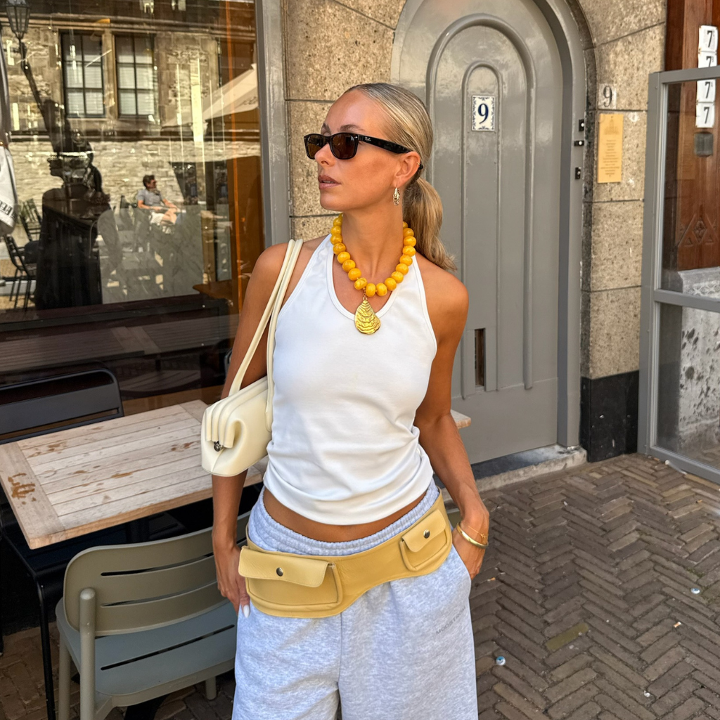 The Ostra Pendant gold styled on a model for a modern summer look.