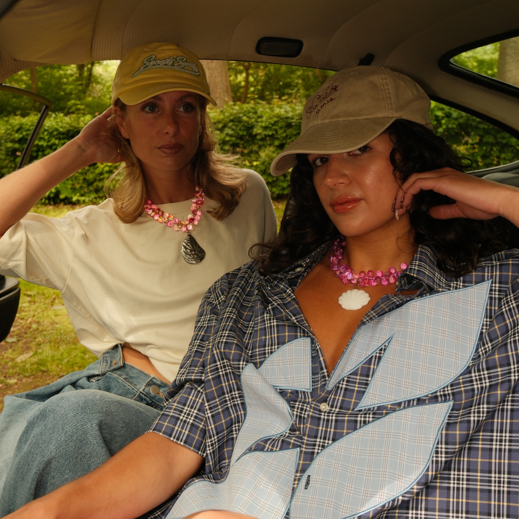 Models wearing the white glass Mermaid 2.0 Pendant for a summery look.